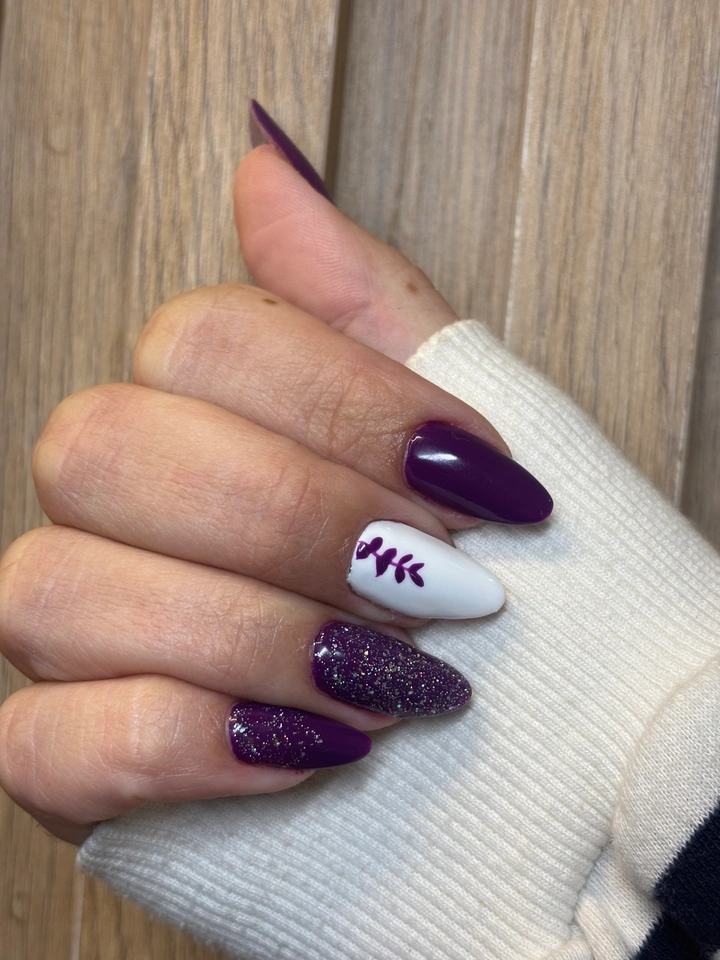 Unhas decoradas em roxo, branco e brilho