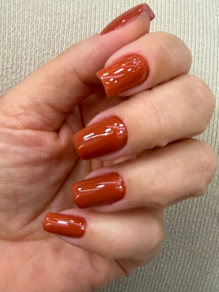 Unhas em tom terracota com acabamento brilhante