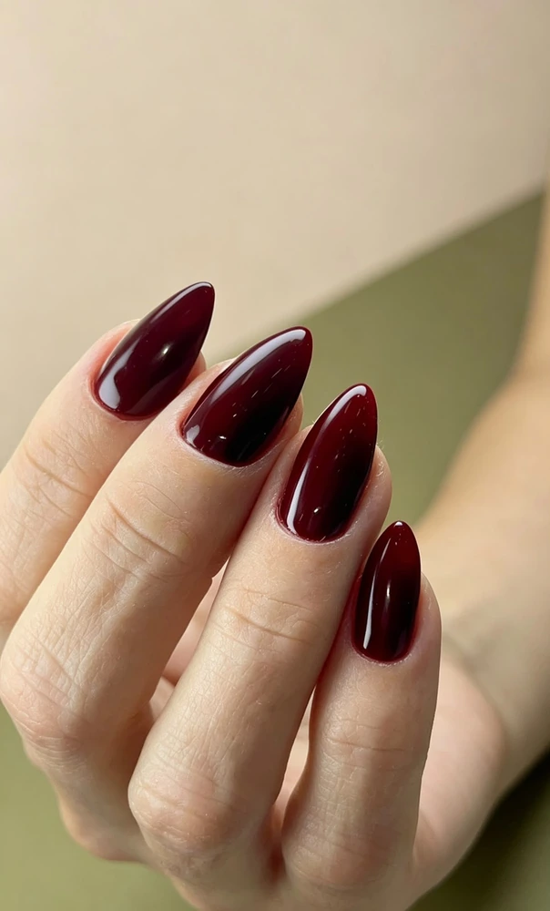 Unhas alongadas em tom vinho com acabamento brilhante