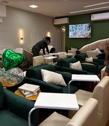 Interior da Entre Nós, com poltronas verdes e espaços de atendimento